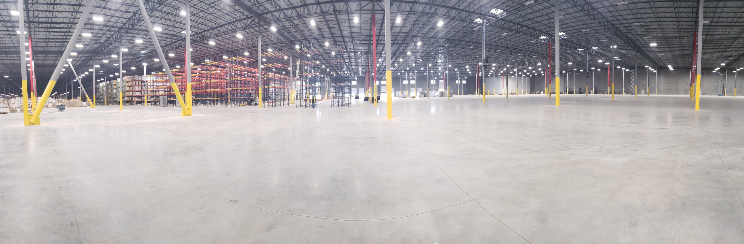 Mid-teardown at the 350,000 sq ft Memphis decommission: racking half down, floor cleared, lift equipment on the floor