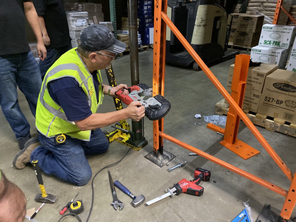 Damaged pallet rack upright before repair