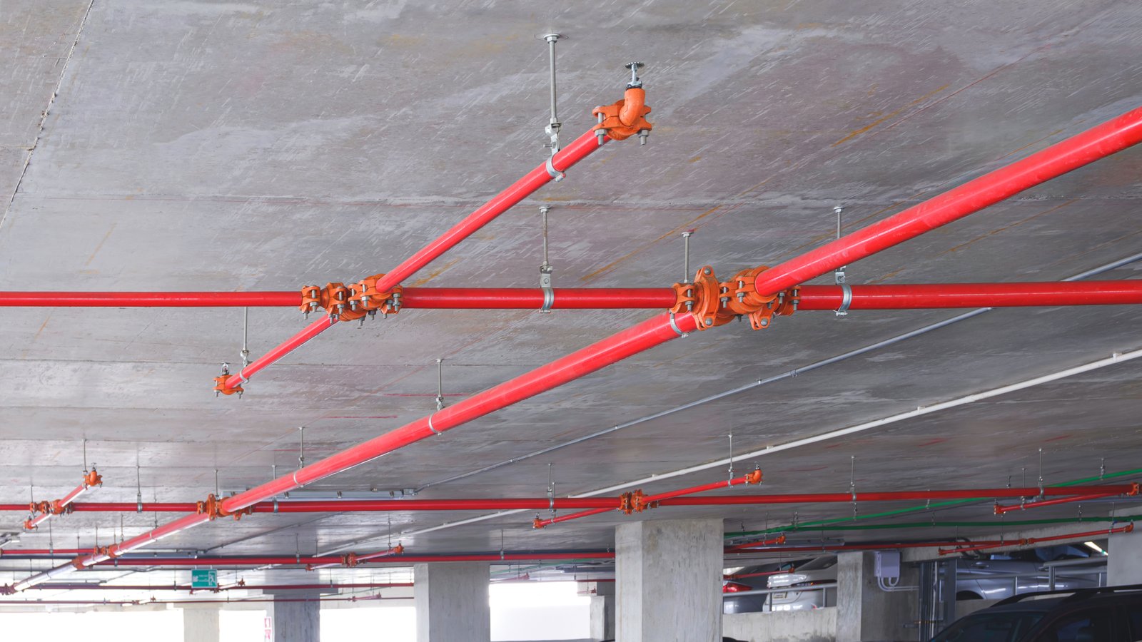 Fire-suppression sprinkler pipes running along a warehouse ceiling, illustrating sprinkler clearance concerns