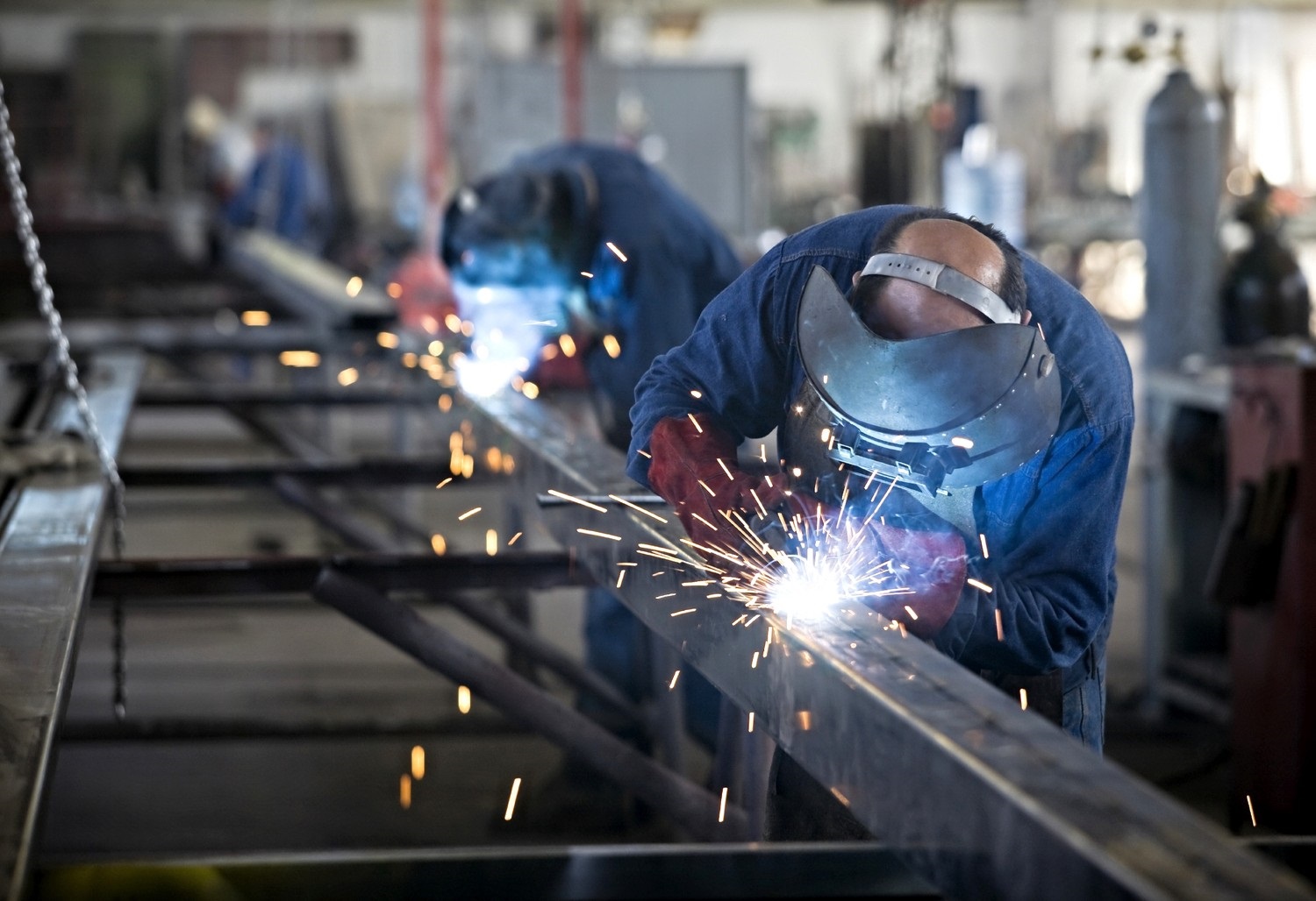 Two fabricators welding steel in the AMH shop