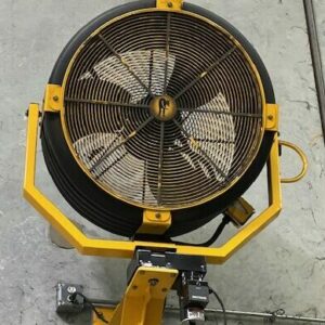 The image shows a large industrial fan mounted on a yellow stand. The fan has a sturdy metal grille with a circular design, protecting the blades. The fan blades are white, and the central hub features a logo or emblem. The mounting stand allows the fan to be positioned securely and adjusted as needed. Below the fan, there is an electrical box connected to power cables, ensuring the fan operates efficiently. The background is a concrete wall, indicating that this fan is likely used in an industrial or warehouse setting to provide ventilation or cooling.